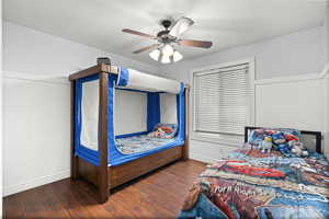 Bedroom featuring baseboards, hardwood / wood-style floors, and a ceiling fan