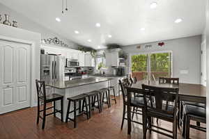 Kitchen with stainless steel appliances, recessed lighting, a breakfast bar, decorative backsplash, and a center island