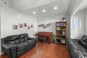 Living area featuring dark wood finished floors, ornamental molding, and recessed lighting