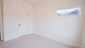 Unfurnished bedroom with light carpet, baseboards, and a closet