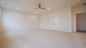 Unfurnished bedroom featuring light colored carpet, baseboards, recessed lighting, a closet, and a ceiling fan