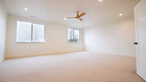 Empty room featuring light carpet, recessed lighting, a ceiling fan, and baseboards