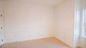 Spare room with a decorative wall and light colored carpet