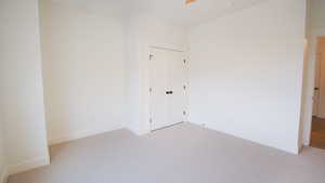 Unfurnished room with light carpet, baseboards, and a smoke detector
