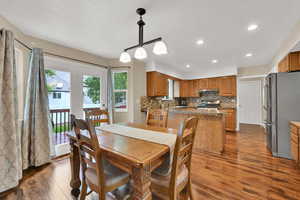 Dining room with dark wood-style floors and recessed lighting