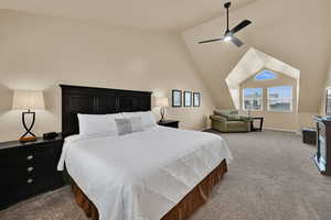 Carpeted bedroom with lofted ceiling, a ceiling fan, and baseboards