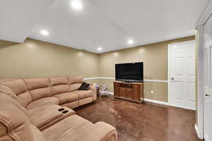 Living area with concrete flooring, recessed lighting, and baseboards