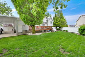 View of yard with a wooden deck and a patio