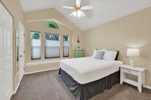 Bedroom with carpet flooring, vaulted ceiling, ceiling fan, and baseboards