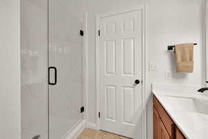 Bathroom with a marble finish shower and vanity