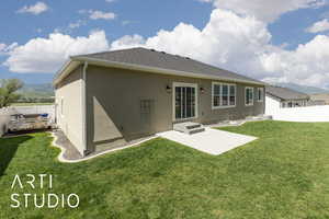 Back of property featuring stucco siding, roof with shingles, a patio area, and a mountain view