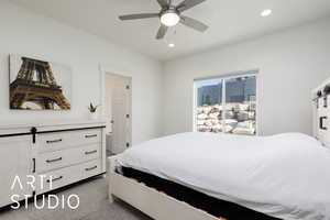 Bedroom with a barn door, recessed lighting, dark carpet, and a ceiling fan