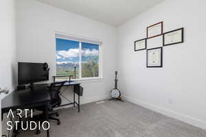 Carpeted home office featuring baseboards