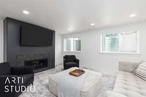Living room with recessed lighting, a glass covered fireplace, and baseboards