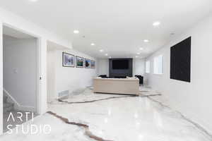 Living area with recessed lighting, stairs, and baseboards