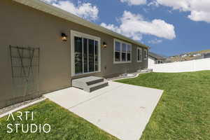 Rear view of house with stucco siding and a patio area
