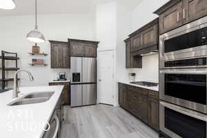 Kitchen with stainless steel appliances, a sink, and dark brown cabinetry