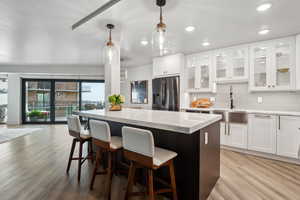 Kitchen featuring stainless steel refrigerator with ice dispenser, a sink, a center island