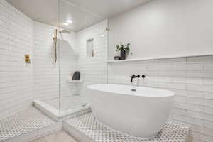 Bathroom with tile walls, a tile shower, a soaking tub