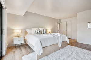 Master bedroom with wood finished floors, baseboards, and a closet