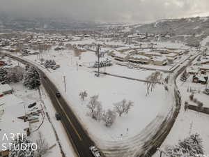 Snowy aerial view featuring a mountain view and a residential view