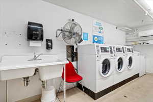 Shared laundry featuring washer and dryer. Extra W/D on opposite wall.