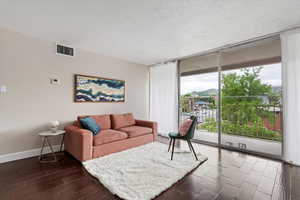 Living room featuring expansive windows, sliding glass doors / deck, and ample natural light.