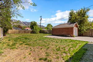 View of yard featuring a detached garage, and concrete driveway