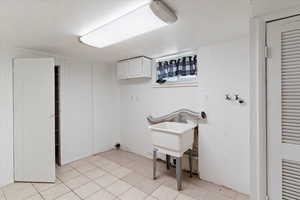 Laundry room featuring cabinet space and light tile patterned floors