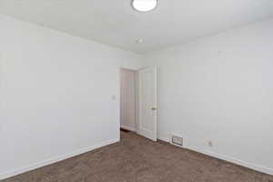 Carpeted bedroom with baseboards and a textured ceiling