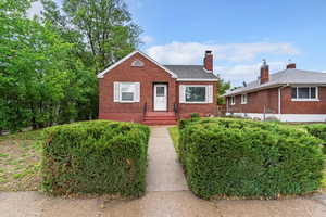 Bungalow-style house featuring brick siding, roof with shingles