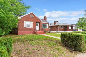 Bungalow-style home with brick siding, and fence