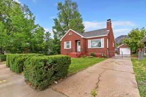Bungalow-style house with brick siding, a detached garage