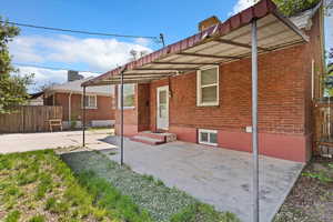Back of house featuring large covered patio, brick siding and fence