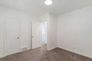 Unfurnished bedroom with carpet, baseboards