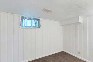 Basement bedroom with a textured ceiling and carpet