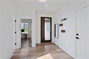 Foyer entrance with baseboards, light wood-type flooring, and recessed lighting