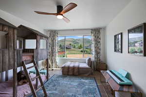 Living area featuring a ceiling fan, wood finished floors, and a mountain view