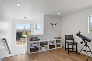 Living area with wood finished floors, plenty of natural light, recessed lighting, and a chandelier