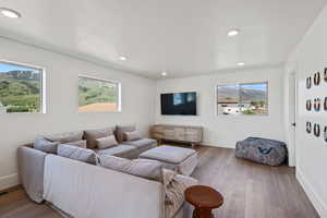 Living room with healthy amount of natural light, hardwood / wood-style floors, and recessed lighting