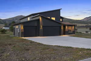 View of front of house featuring a mountain view, driveway, board and batten siding, and a garage