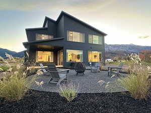 Rear view of property with a patio, an outdoor fire pit, and a mountain view