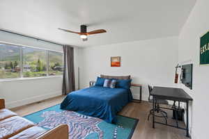 Bedroom with wood finished floors, baseboards, and a ceiling fan