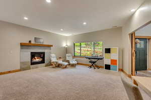 Sitting room featuring carpet flooring, baseboards, recessed lighting, and a tile fireplace