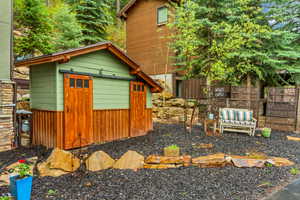 View of side of home featuring fence and an outdoor structure