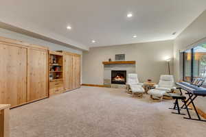 Sitting room featuring carpet floors, a tiled fireplace, recessed lighting, and baseboards