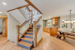 Stairs featuring wood-type flooring, a chandelier, and recessed lighting