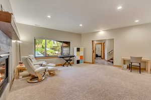 Sitting room featuring carpet, recessed lighting, baseboards, stairs, and a fireplace
