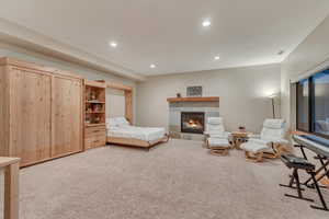 Bedroom featuring carpet, recessed lighting, and a fireplace