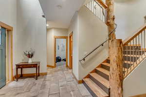 Entryway with stairway and baseboards